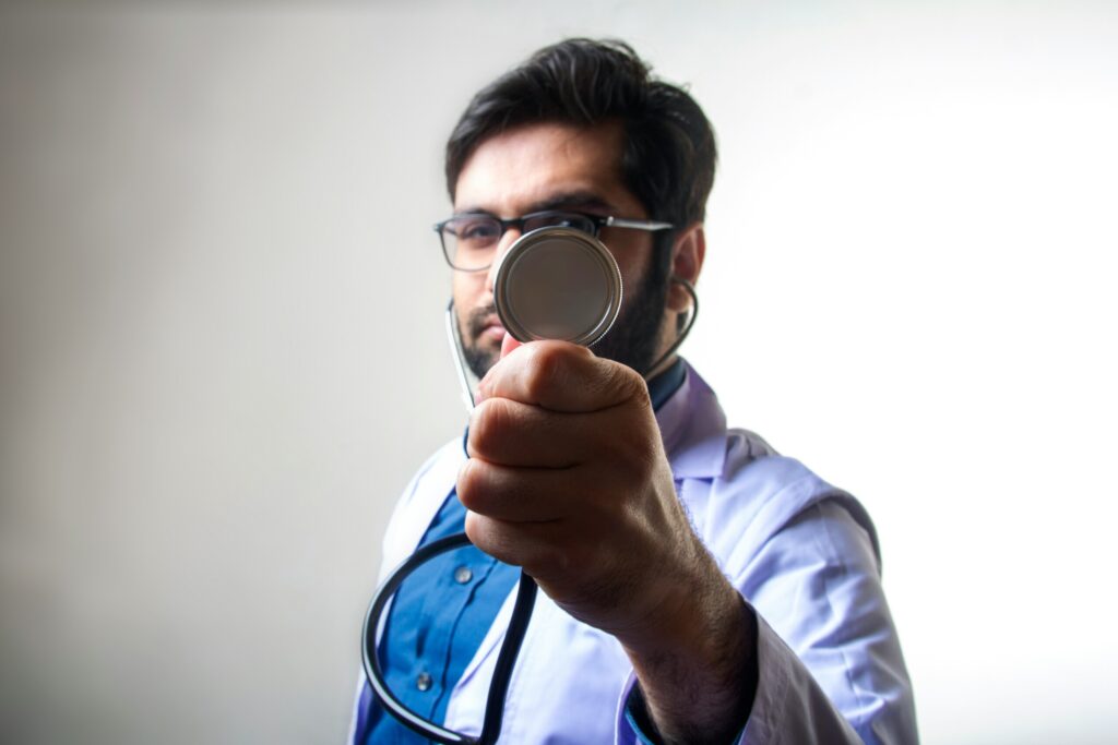 male physician holding magnifying glass
